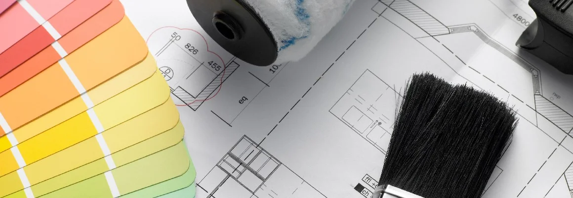 Farbpalette, Farbrolle und Pinsel auf einem Bauplan.